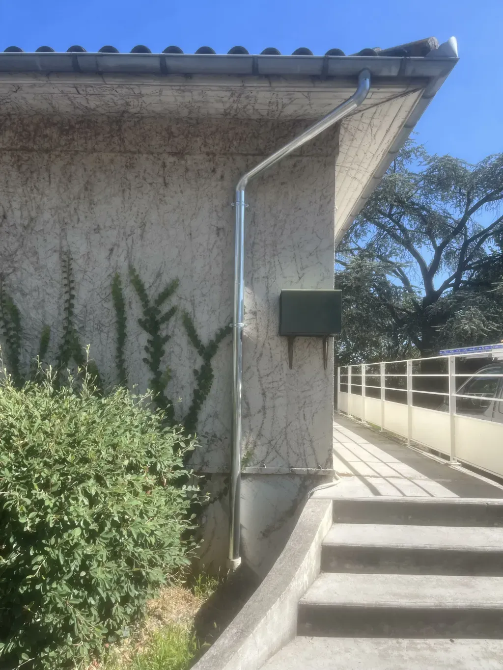 Descente d’eau pluviale métallique fixée sur une façade