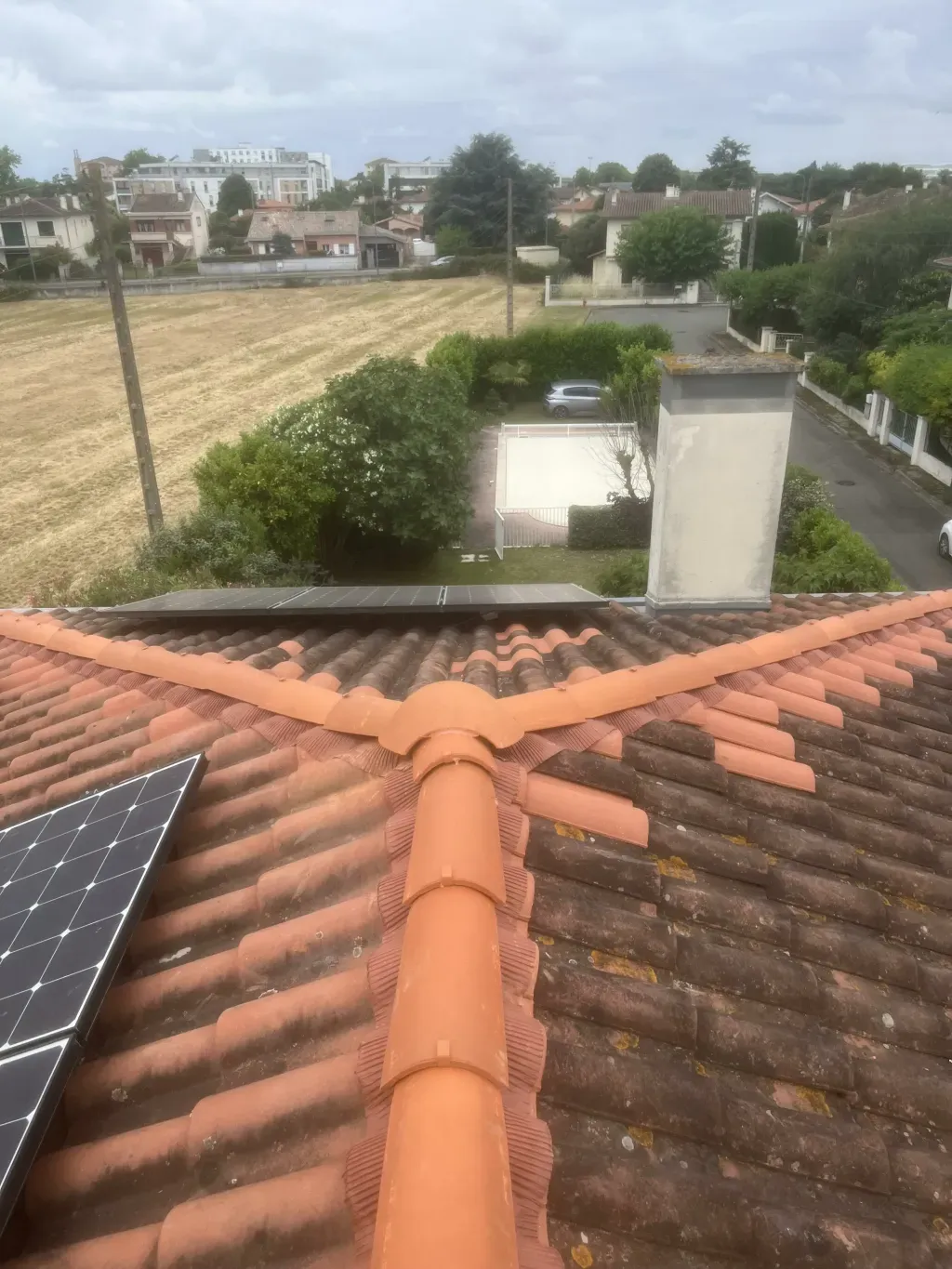 Faîtage rénové en tuiles de terre cuite sur une toiture ancienne équipée de panneaux solaires