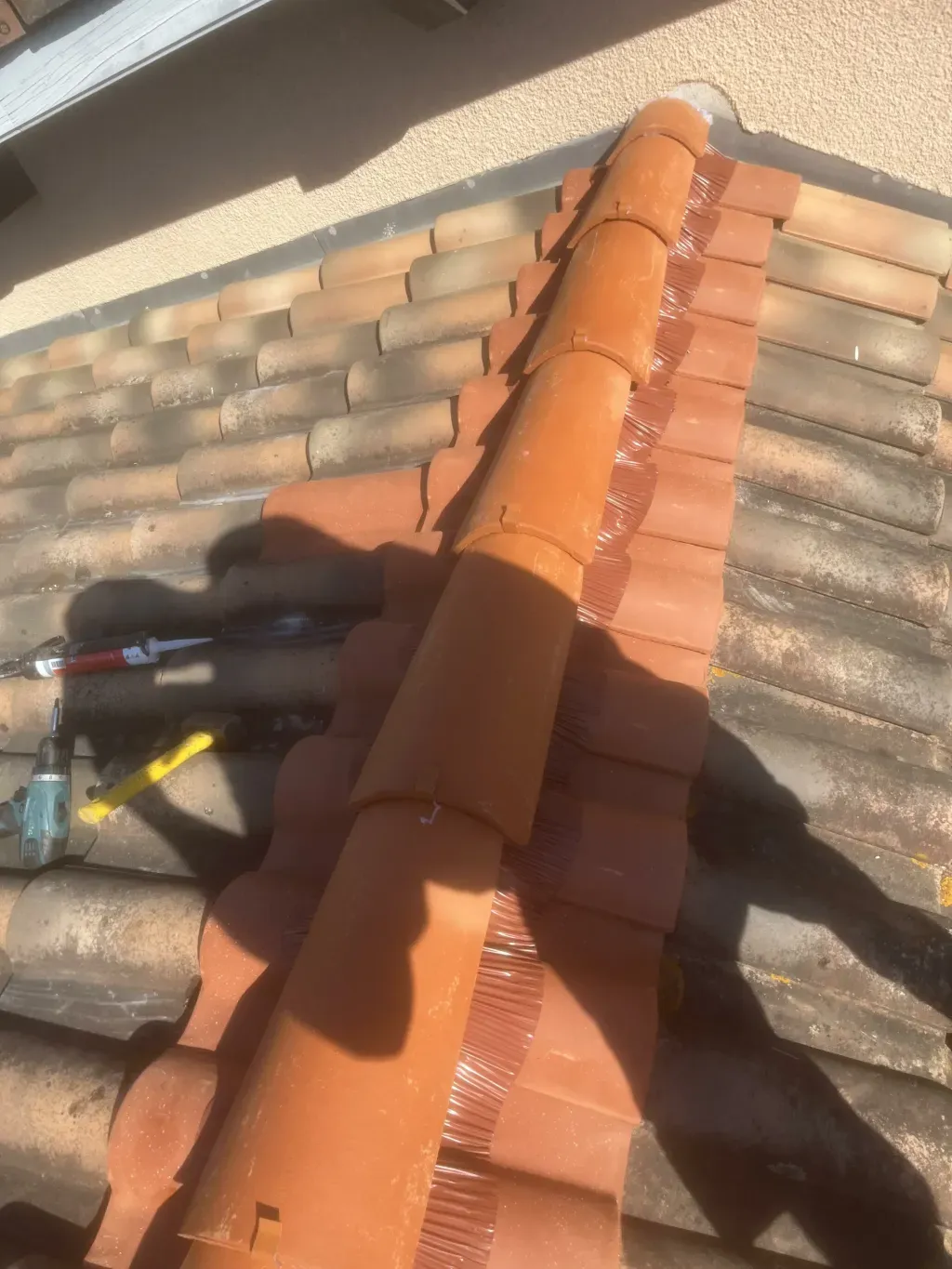 Pose d’un faîtage en tuiles de terre cuite avec closoir ventilé sur une toiture ancienne