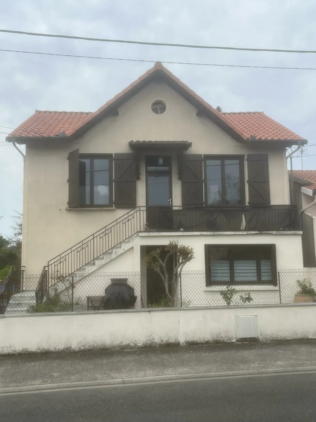 Maison à étage avec balcon et toiture à plusieurs pans en tuiles de terre cuite