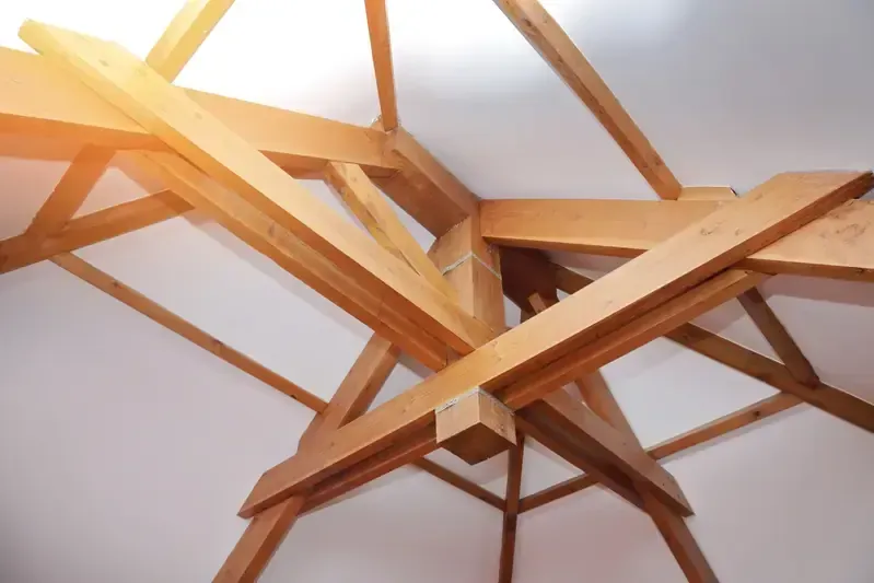 Charpente rénovée en bois apparent sous un plafond blanc